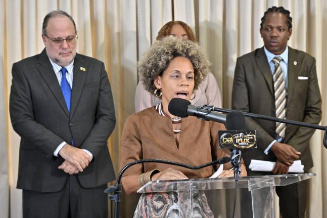 Deputy Spokesperson on Education Dr Maziki Thame addresses a press conference on Monday as Opposition Leader Mark Golding (left) and Education Spokesperson Damion Crawford (right) look on.