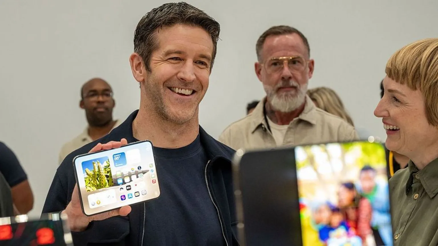 AFP via Getty Image Apple boss John Ternus showing off the new iPhone Duo to visitors at the firm's headquarters.